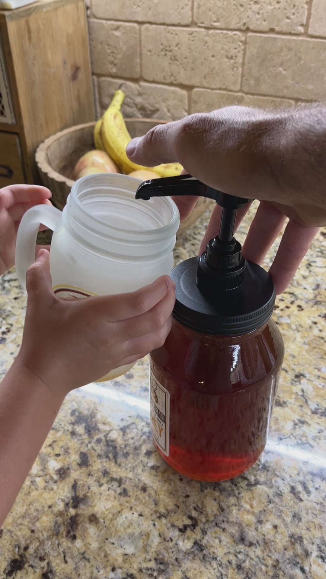 video of man pumping honey into a plastic mug that his child is holding mess free
